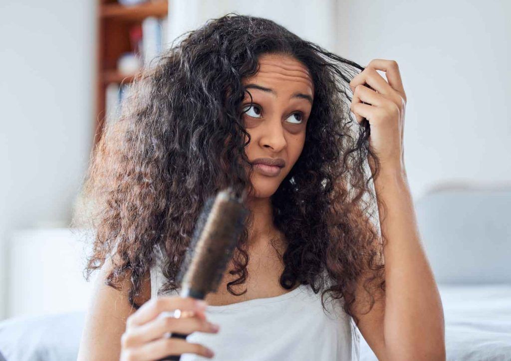 mujer mirando su cabello rizado
