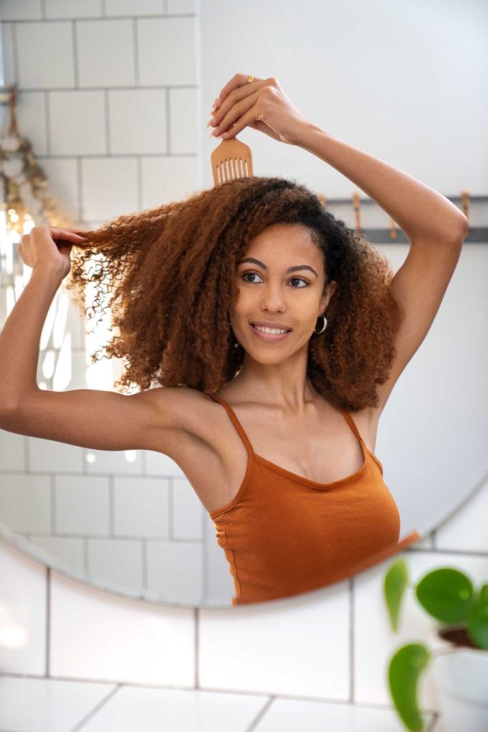 mujer joven teniendo cuidado afro cabello