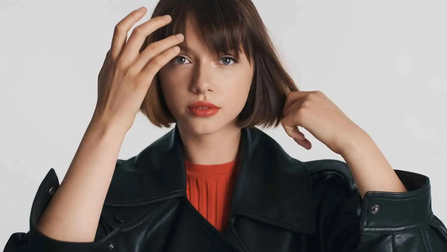 atractiva chica morena casual labios rojos acicalandose pelo confianza camara sobre fondo blanco