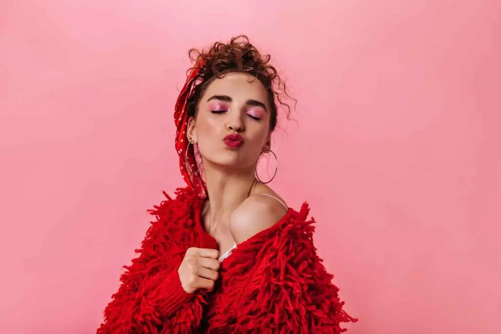 hermosa dama abrigo rojo soplando beso rosa