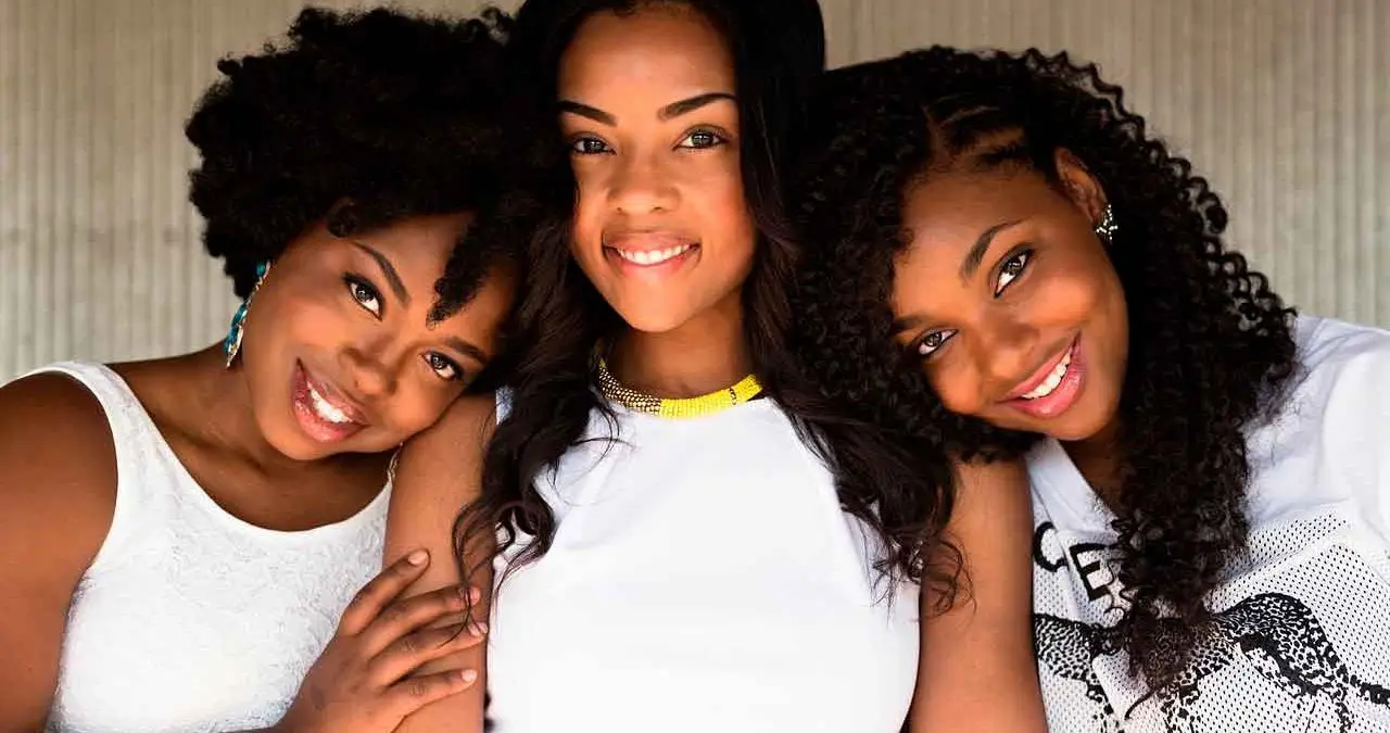 tres mujeres con cabello rizado