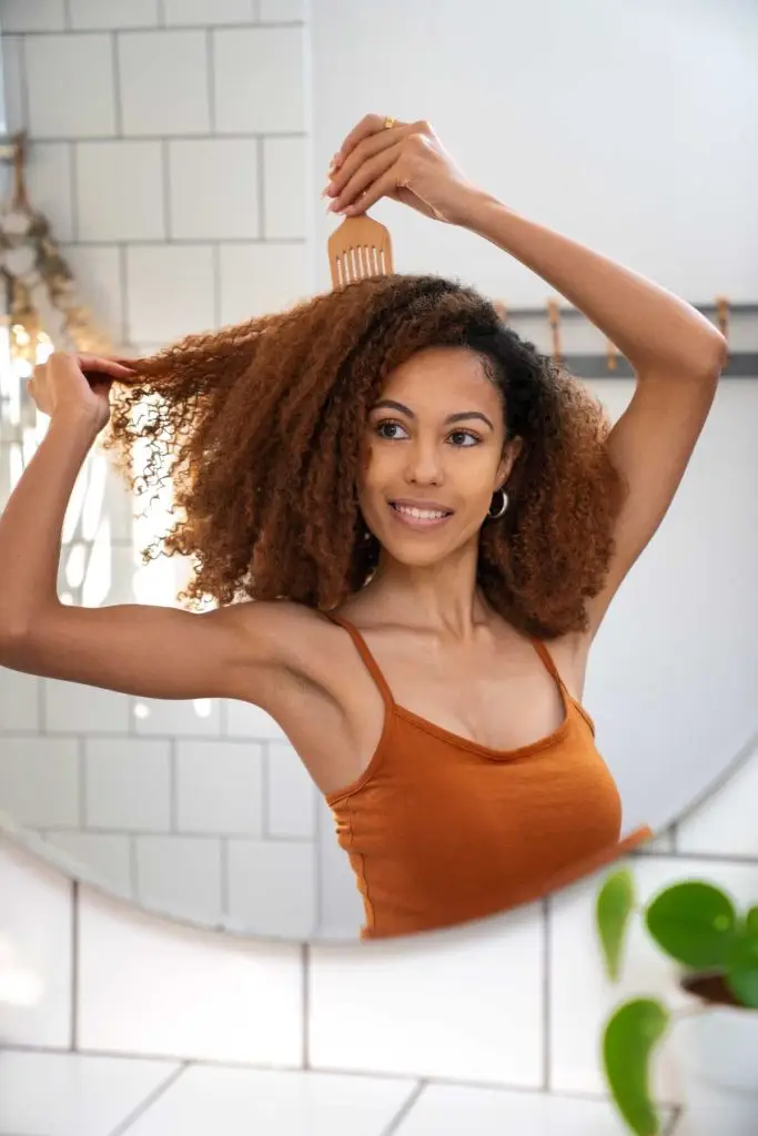 mujer joven teniendo cuidado afro cabello